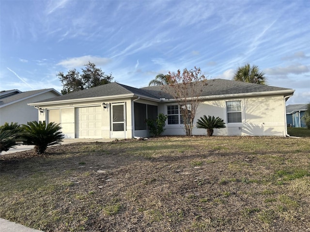 single story home featuring a garage and a front lawn