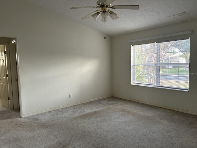 carpeted spare room with a textured ceiling, ceiling fan, and vaulted ceiling