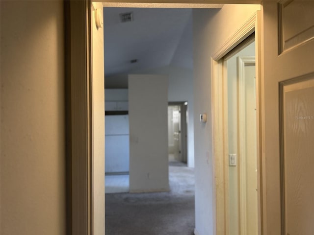 hall with carpet flooring and vaulted ceiling