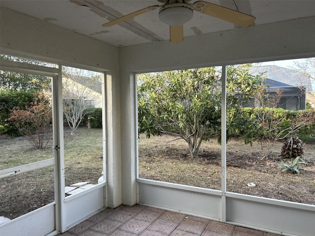 unfurnished sunroom with ceiling fan