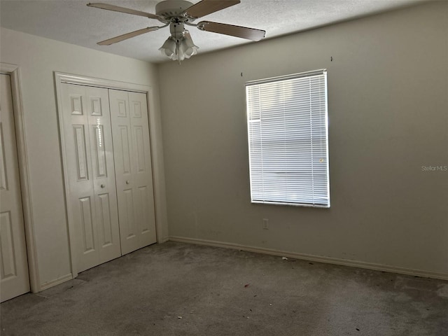 unfurnished bedroom with light colored carpet, ceiling fan, a textured ceiling, and a closet