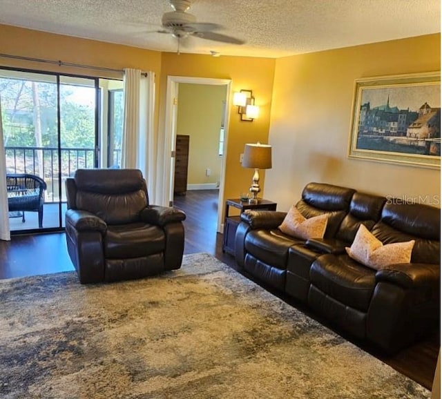 living room with ceiling fan, wood-type flooring, and a textured ceiling