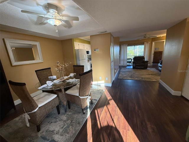 dining room with ceiling fan, a textured ceiling, and dark hardwood / wood-style flooring