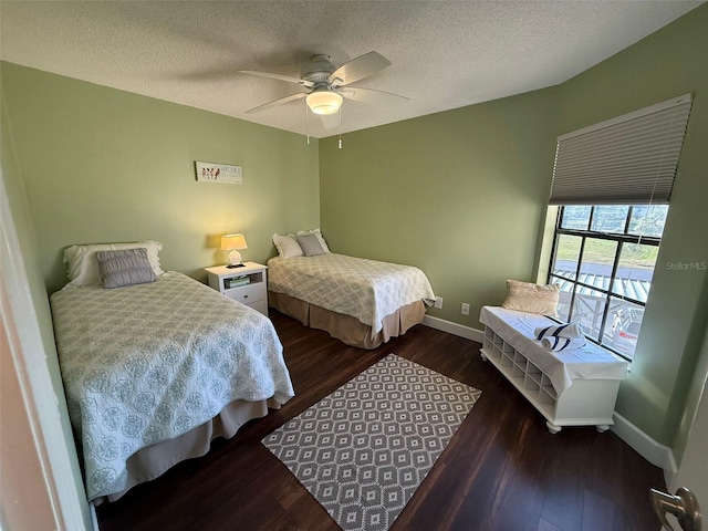 bedroom with ceiling fan, dark hardwood / wood-style floors, and a textured ceiling