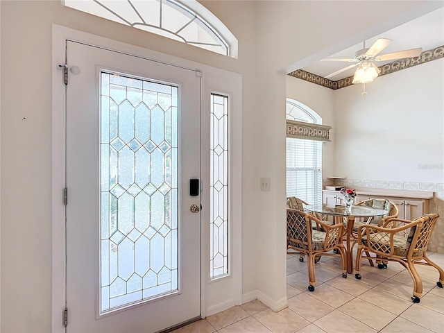 tiled entryway with ceiling fan and breakfast area