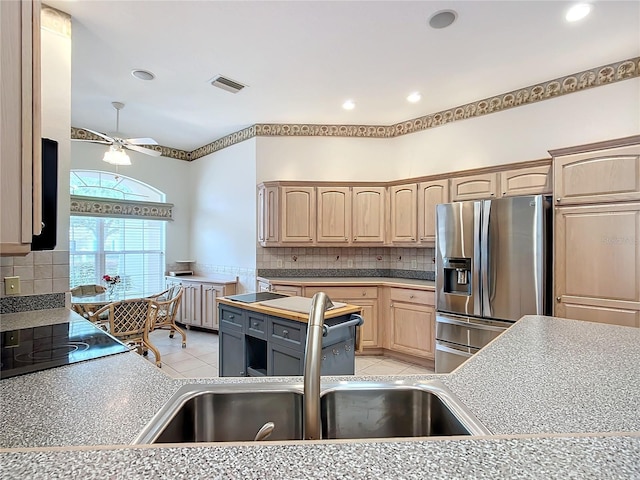 kitchen with stainless steel fridge with ice dispenser, light tile patterned flooring, light brown cabinets, and sink