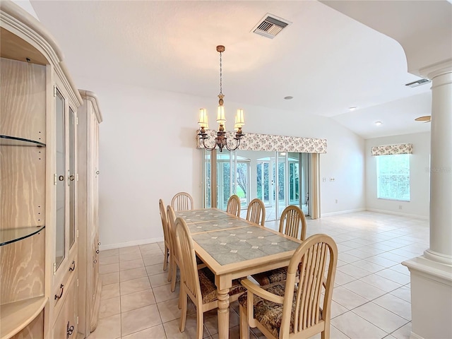 dining space with a notable chandelier, light tile patterned floors, vaulted ceiling, and decorative columns