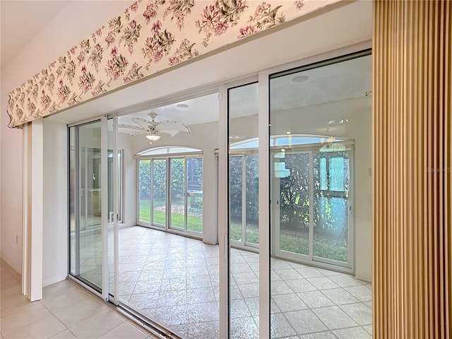 doorway to outside with ceiling fan and light tile patterned floors