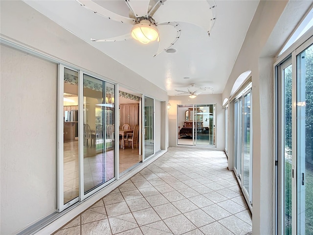 unfurnished sunroom featuring ceiling fan