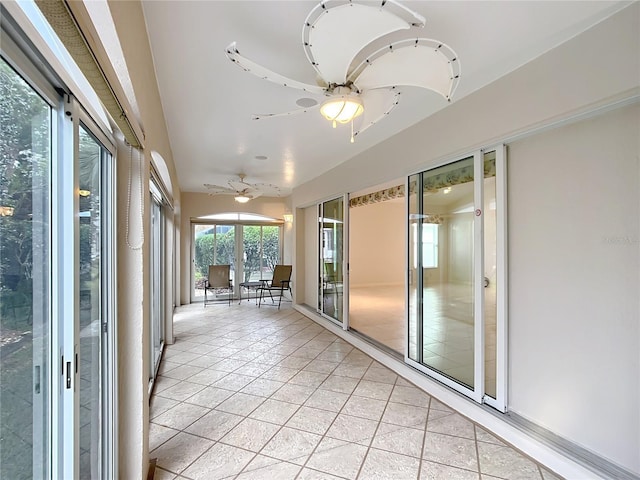 unfurnished sunroom featuring ceiling fan