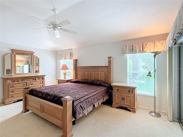 carpeted bedroom featuring ceiling fan and multiple windows