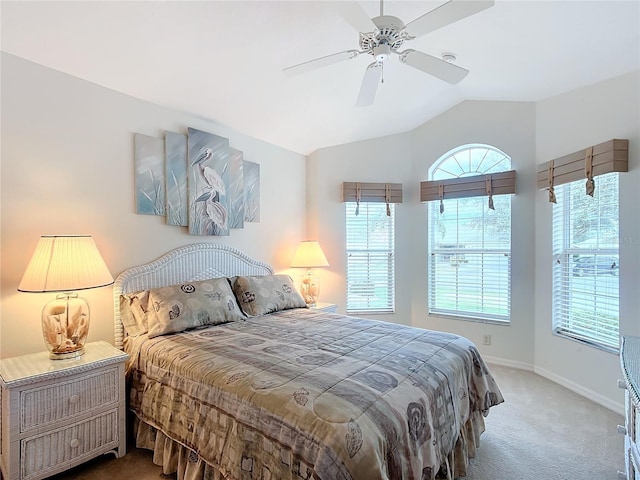 carpeted bedroom with ceiling fan and vaulted ceiling