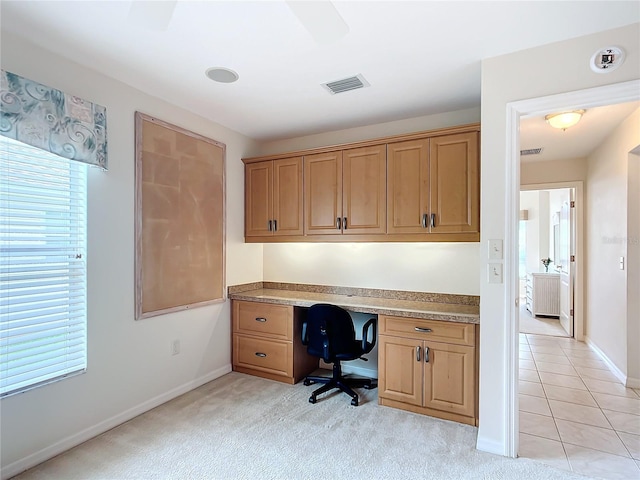 carpeted home office featuring built in desk