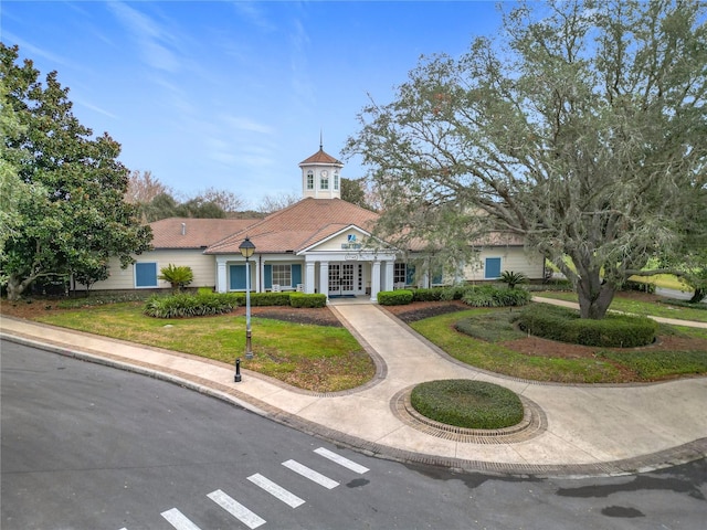 view of front facade with a front lawn and french doors