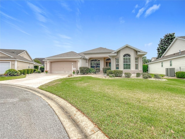 view of front of property featuring a front lawn, a garage, and cooling unit