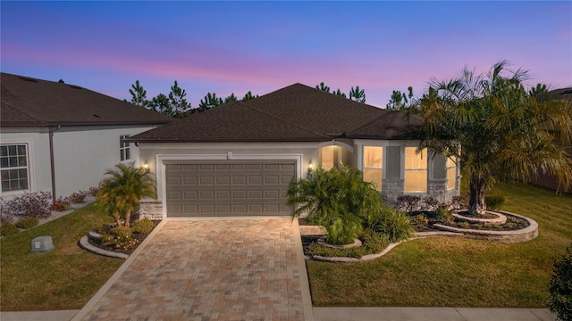 view of front of property featuring a garage and a yard