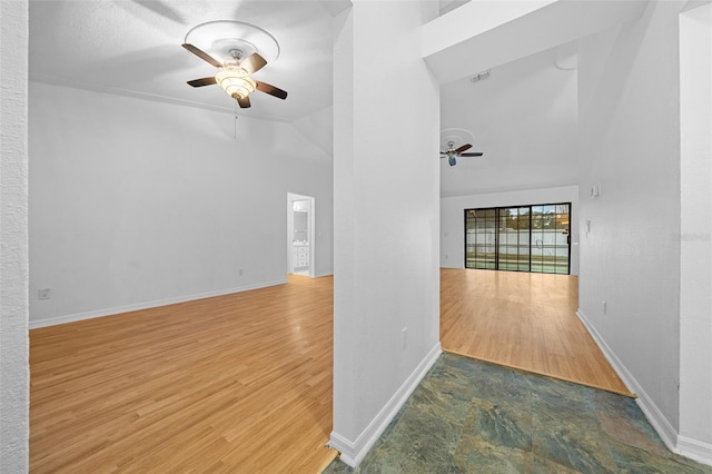 unfurnished living room featuring lofted ceiling, ceiling fan, and dark hardwood / wood-style floors