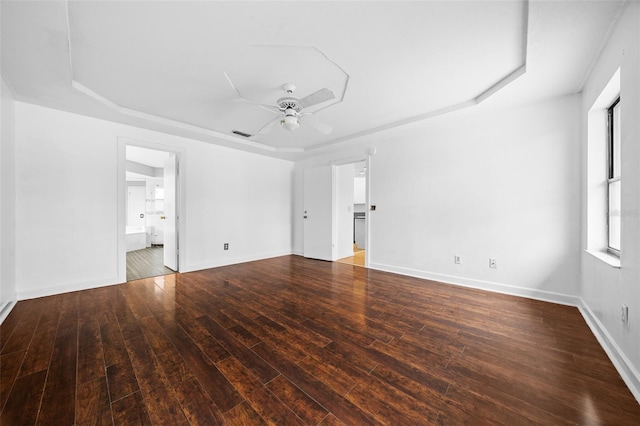 spare room with a tray ceiling, ceiling fan, and hardwood / wood-style flooring