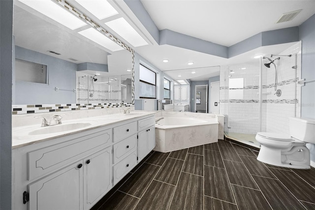 full bathroom featuring decorative backsplash, vanity, tile walls, shower with separate bathtub, and toilet