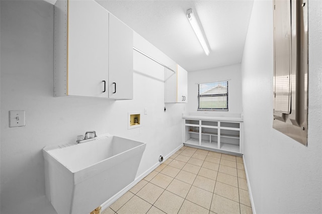 clothes washing area with sink, cabinets, electric dryer hookup, hookup for a washing machine, and light tile patterned floors