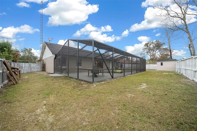 rear view of property with a storage shed, a patio area, and a lawn