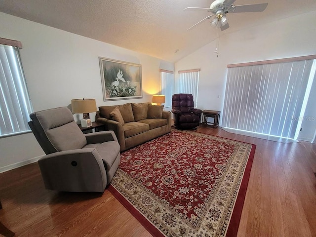 living room with ceiling fan, vaulted ceiling, and wood-type flooring