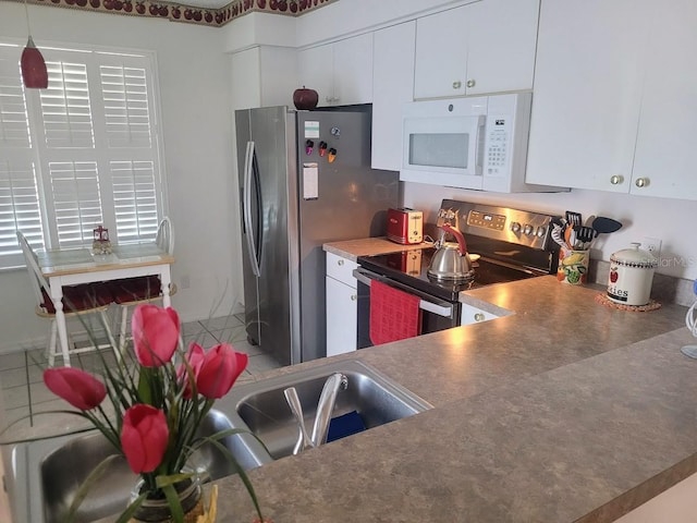 kitchen with stainless steel appliances, decorative light fixtures, and white cabinetry