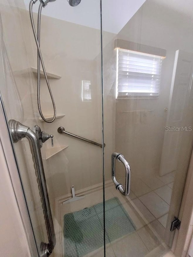 bathroom featuring walk in shower and tile patterned flooring