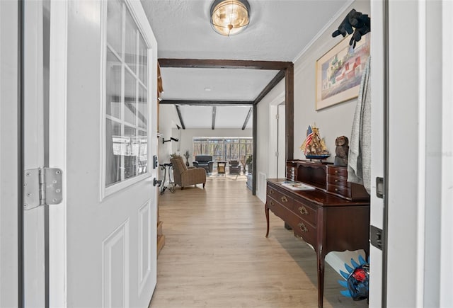 hall with lofted ceiling with beams, light wood-type flooring, and a textured ceiling