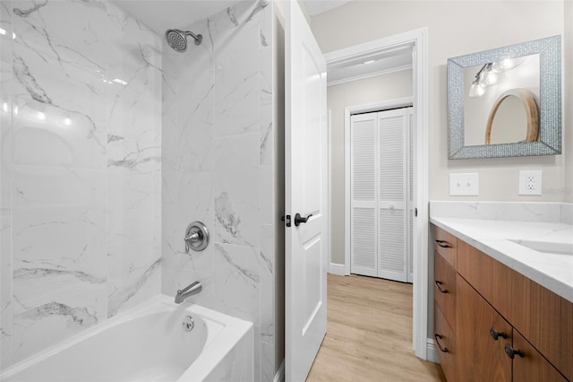 bathroom with tiled shower / bath, vanity, crown molding, and hardwood / wood-style flooring