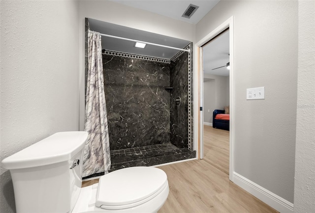 bathroom featuring toilet, hardwood / wood-style floors, ceiling fan, and curtained shower