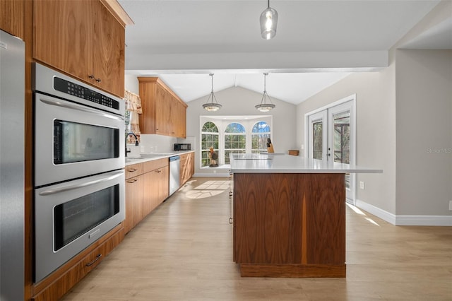 kitchen with decorative light fixtures, stainless steel appliances, french doors, and a kitchen island