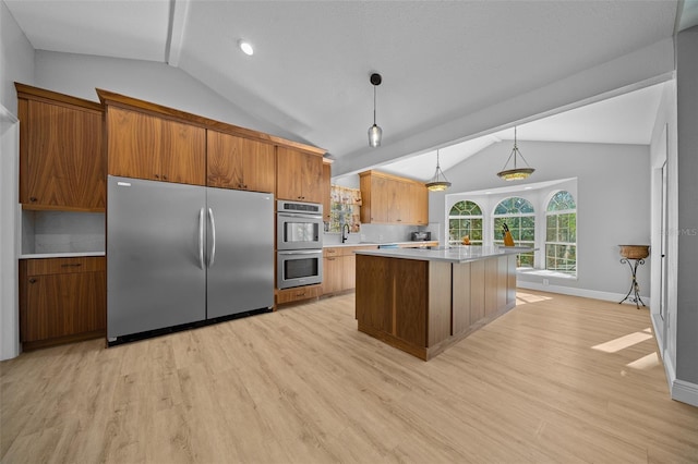 kitchen with decorative light fixtures, lofted ceiling, a center island, light hardwood / wood-style flooring, and stainless steel appliances