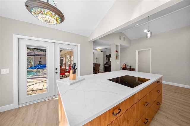 kitchen featuring lofted ceiling, a kitchen island, decorative light fixtures, french doors, and black electric cooktop