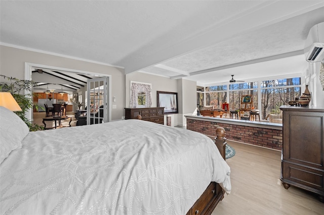 bedroom with an AC wall unit, beamed ceiling, and light hardwood / wood-style flooring