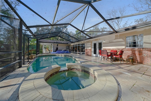 view of pool featuring french doors, a patio, glass enclosure, and an in ground hot tub