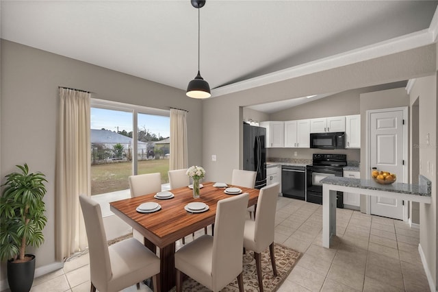 tiled dining space featuring vaulted ceiling