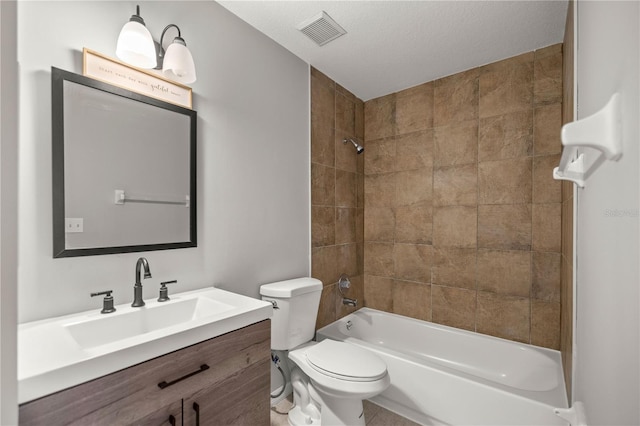 full bathroom with toilet, vanity, a textured ceiling, and tiled shower / bath