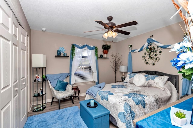 bedroom with ceiling fan, a textured ceiling, hardwood / wood-style flooring, and a closet