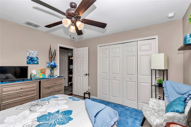 bedroom with ceiling fan, a textured ceiling, a closet, and carpet flooring