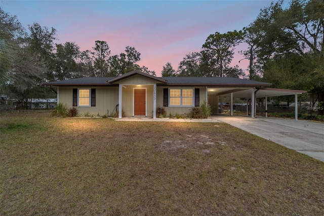 ranch-style home featuring a carport and a yard