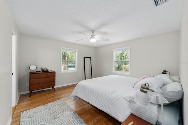 bedroom with ceiling fan and light hardwood / wood-style flooring