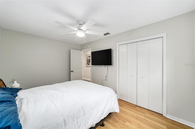 bedroom with ceiling fan, a closet, and light hardwood / wood-style flooring