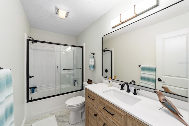 full bathroom featuring a textured ceiling, shower / bath combination with glass door, vanity, and toilet