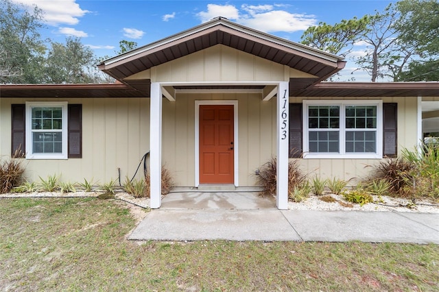 entrance to property with a lawn