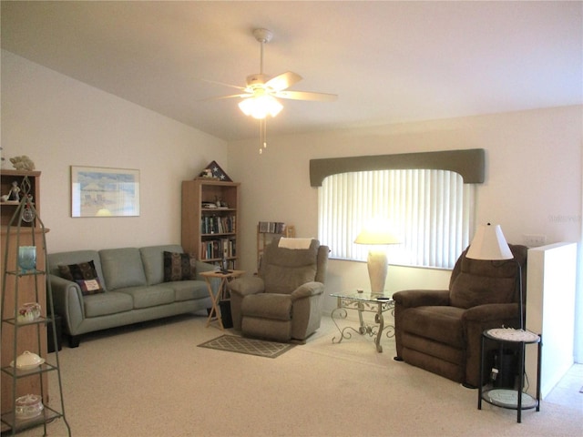 carpeted living room with ceiling fan and vaulted ceiling