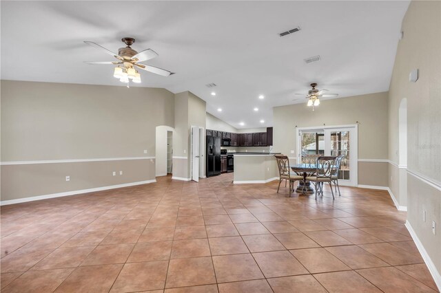 interior space featuring vaulted ceiling, black appliances, ceiling fan, dark brown cabinets, and light tile patterned flooring