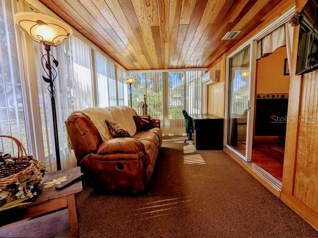 sunroom with a wall mounted air conditioner and wood ceiling