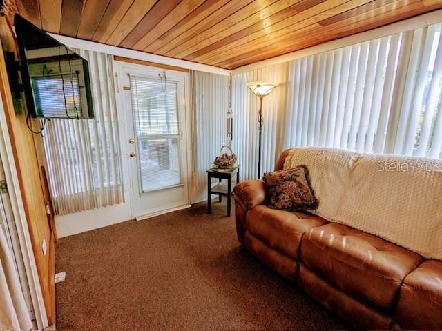 living room with dark colored carpet and wooden ceiling