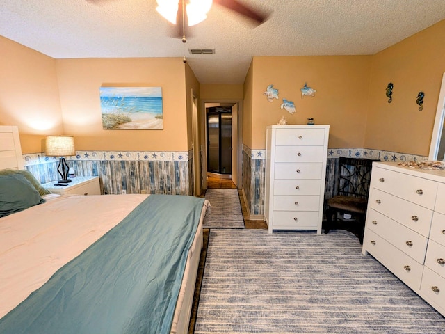 bedroom with ceiling fan and a textured ceiling